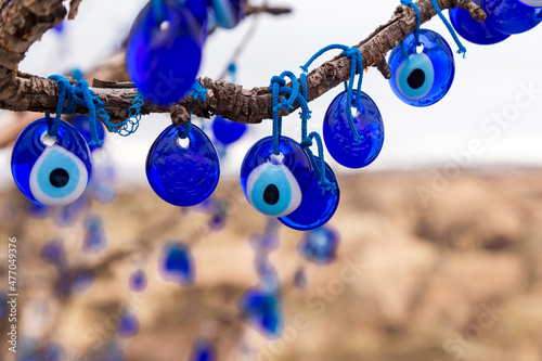 Blue evil eye, nazar boncugu, Turkish symbols hanging on a tree; Cappadocia photo