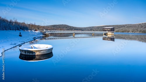 Winter scenery with mountain forests and water reservoir