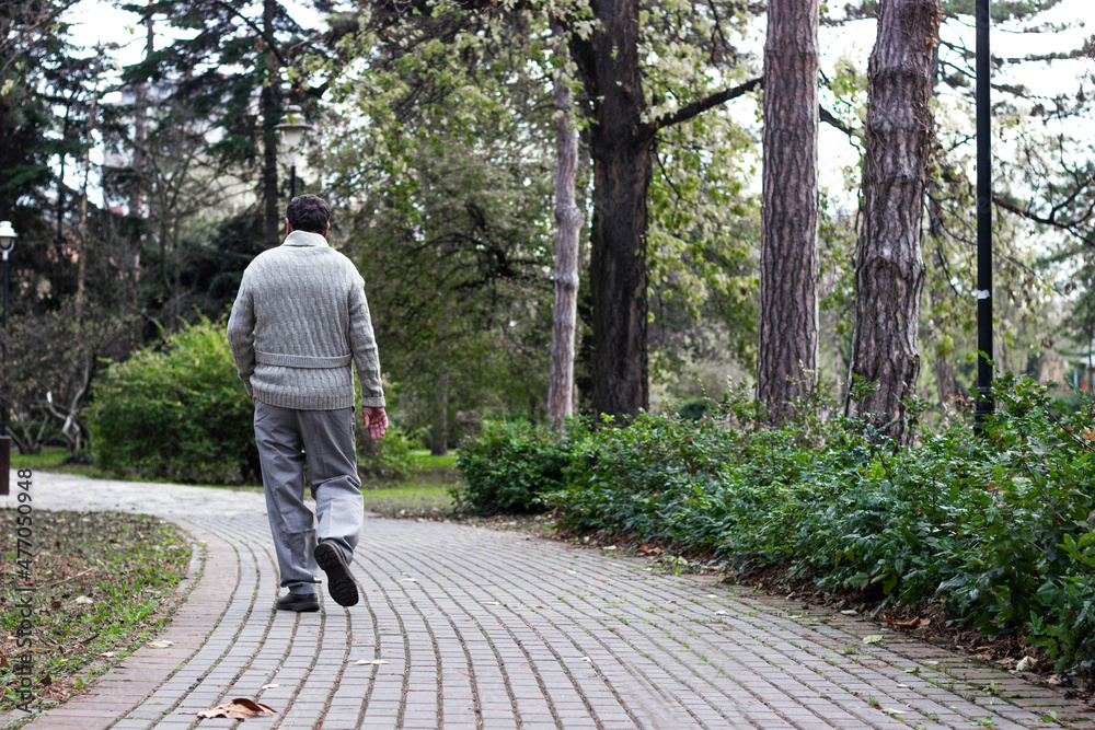 Senior man walking and relaxing in park