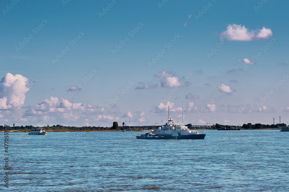 Ships on the river in the summer. Coast Guard boats and a small cruise ship. Partly cloudy. Amur River, Blagoveshchensk, Russia.