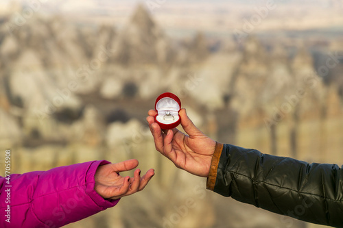 : wedding, marriage proposal in Cappadocia, Man gives wedding ring to his lover, fiance, girlfriend in hot air balloon. Fairy tale chimneys with blue sky