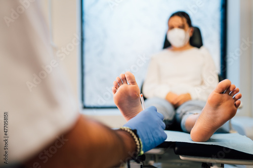 Chiropodist exploring a patient with diabetic foot in the medical center.