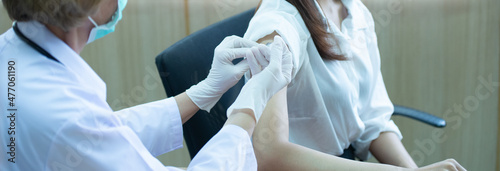 A doctor holds a syringe containing a vaccine against the disease at the hospital, injecting it to prevent coronavirus disease for the people.