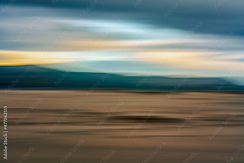 Sunset over sand dunes abstract background. Mountains and colorful cloudy sky on background