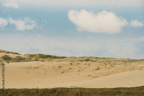 Sand dunes on the beach and cloudy sky, landscape background