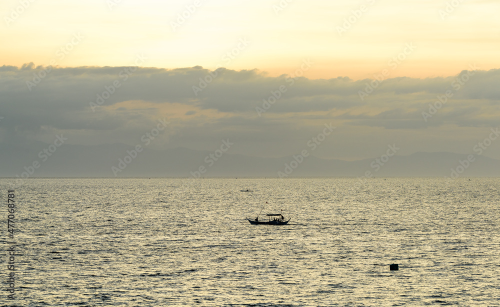 A gorgeous sunset over the Pacific Ocean with silhouette shots of fishing boats. 