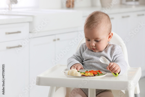 Cute little baby eating healthy food at home. Space for text