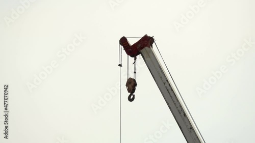 A shot of a lifting hook and extended hydraulic arm of a mobile crane, the machine supporting with the movement of heavy equipment on a construction site photo