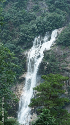 The beautiful countryside view with the waterfall flowing in the mountains after the rainy day