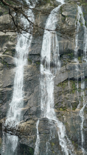 The beautiful countryside view with the waterfall flowing in the mountains after the rainy day