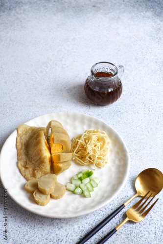 a plate of pempek kapal selam served with noodles and sauce named cuko, it is a traditional cuisine from Palembang, Indonesia photo