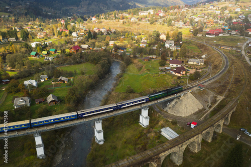 Aerial view of train on bridge and village
