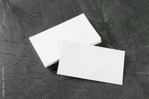 Blank business cards on grey table, above view. Mockup for design