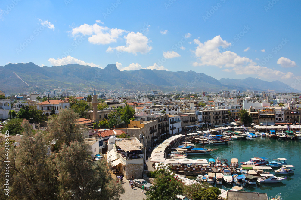 KYRENIA . CYPRUS.View from the fortress on the Cyrenian Harbor, houses of Kyrenia, mountains and blue sky with clouds...