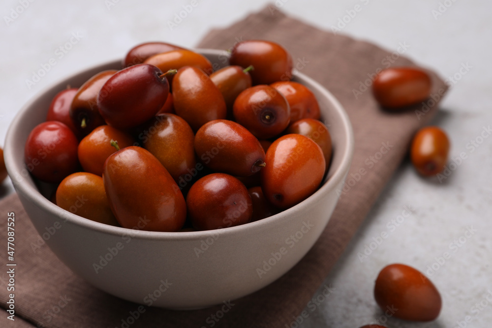 Fresh Ziziphus jujuba fruits with bowl and napkin on table, closeup Fresh Ziziphus jujuba fruits with bowl and napkin on table, closeup