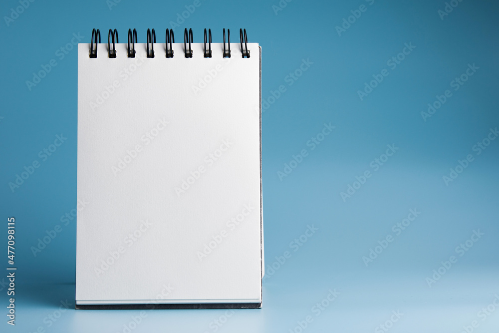 Blank notebook, spiral notebook
on blue background. with copy space Blank notebook, spiral notebook
on blue background. with copy space