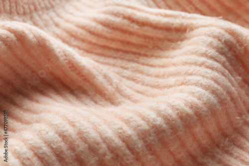 Beautiful pale pink knitted fabric as background, closeup