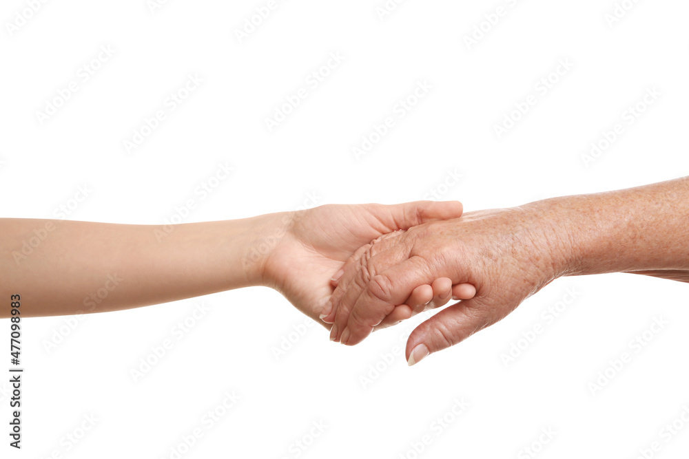 Young and elderly women holding hands together on white background, closeup Young and elderly women holding hands together on white background, closeup
