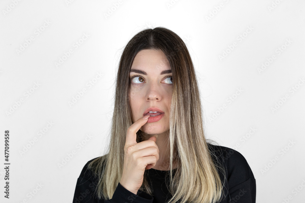 Young beautiful girl wearing casual clothes over isolated white background with hand on mouth thinking about question, pensive expression. Smiling with thoughtful face. Doubt concept. Young beautiful girl wearing casual clothes over isolated white background with hand on mouth thinking about question, pensive expression. Smiling with thoughtful face. Doubt concept.