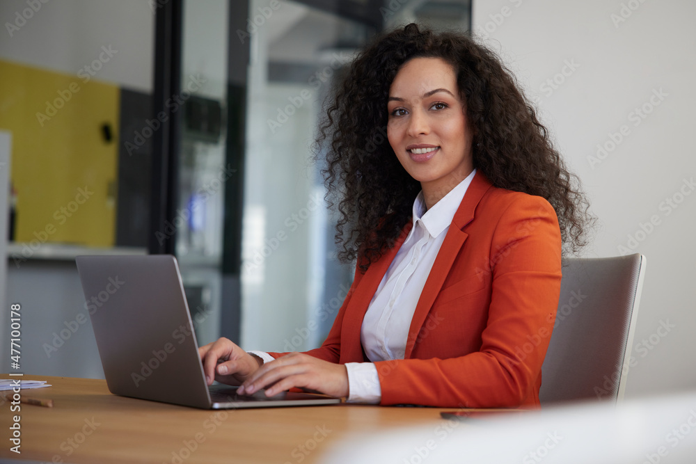 Smiling businesswoman with laptop on desk at workplace Smiling businesswoman with laptop on desk at workplace