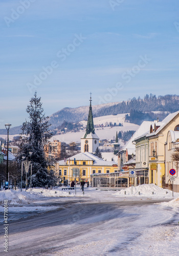 Dolny Kubin, Slovakia - December 26 2021: City centre of Dolny Kubin during Christmas time. Hviezdoslavov Square with towers of local churches. Snowy landscape and historic houses. Orava region