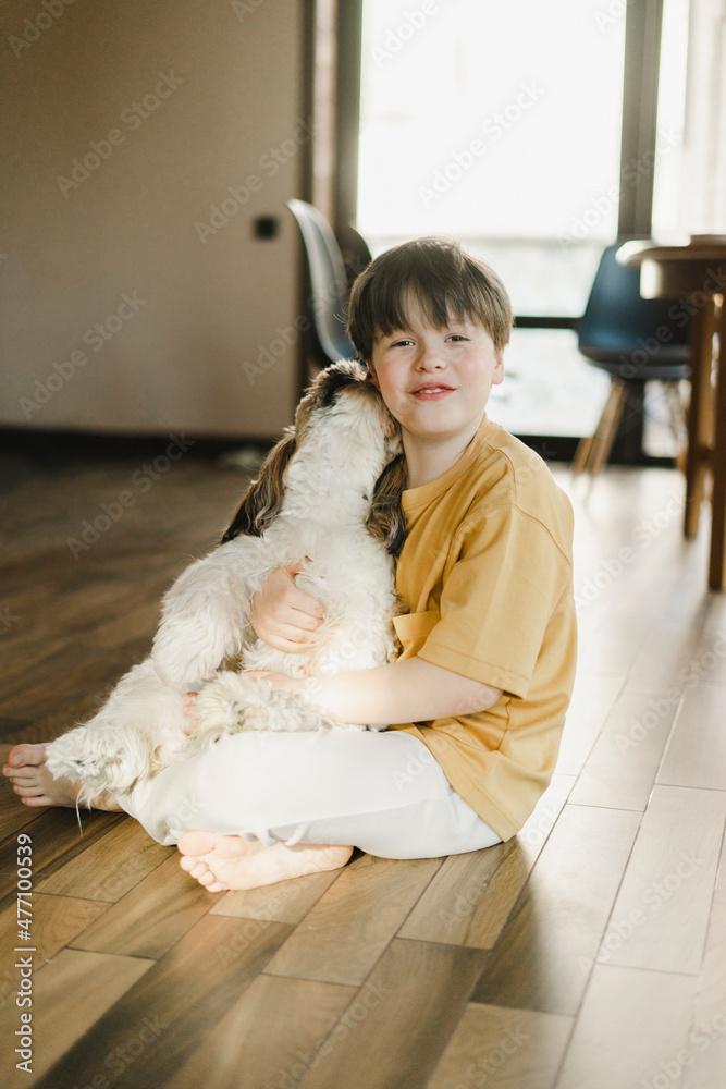 Boy sitting with dog on floor at home Boy sitting with dog on floor at home
