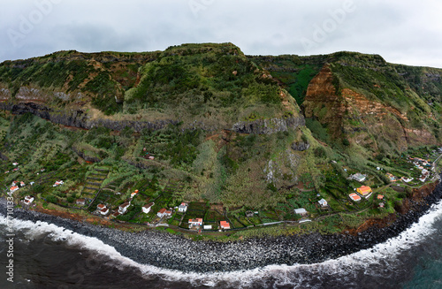Houses on coast with mountain range at Rocha da Relva, Sao Miguel Island, Azores, Portugal photo