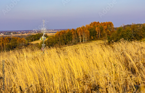 Autumn panoramic view of hills with fields and meadows with field cross shrine surrounding Zagorzyce village south Sedziszow Malopolski town in Podkarpacie region of Lesser Poland
