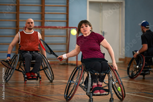 People in wheelchair playing tennis on court. Wheel Chair Tennis For Disabled. photo