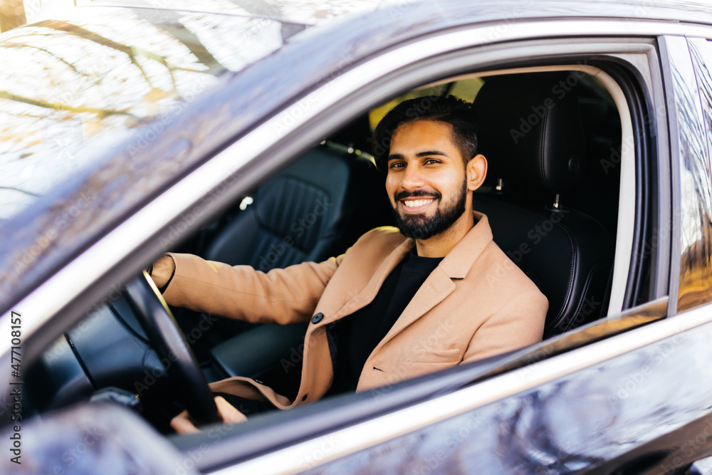 Young indian man driving a car on the street