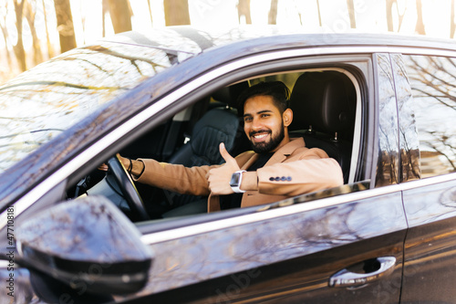 Young asian man smiling and showing thumb up in the car. © F8  \ Suport Ukraine