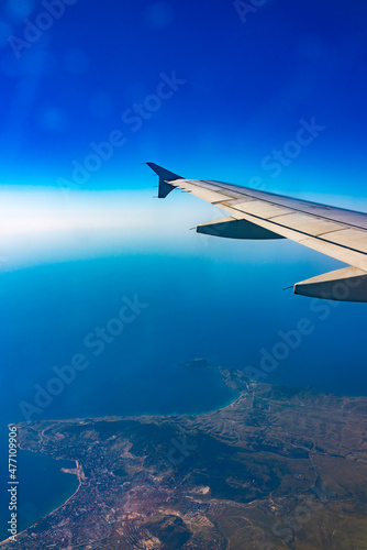 View from the airplane window at a beautiful blue clear sky and the airplane wing