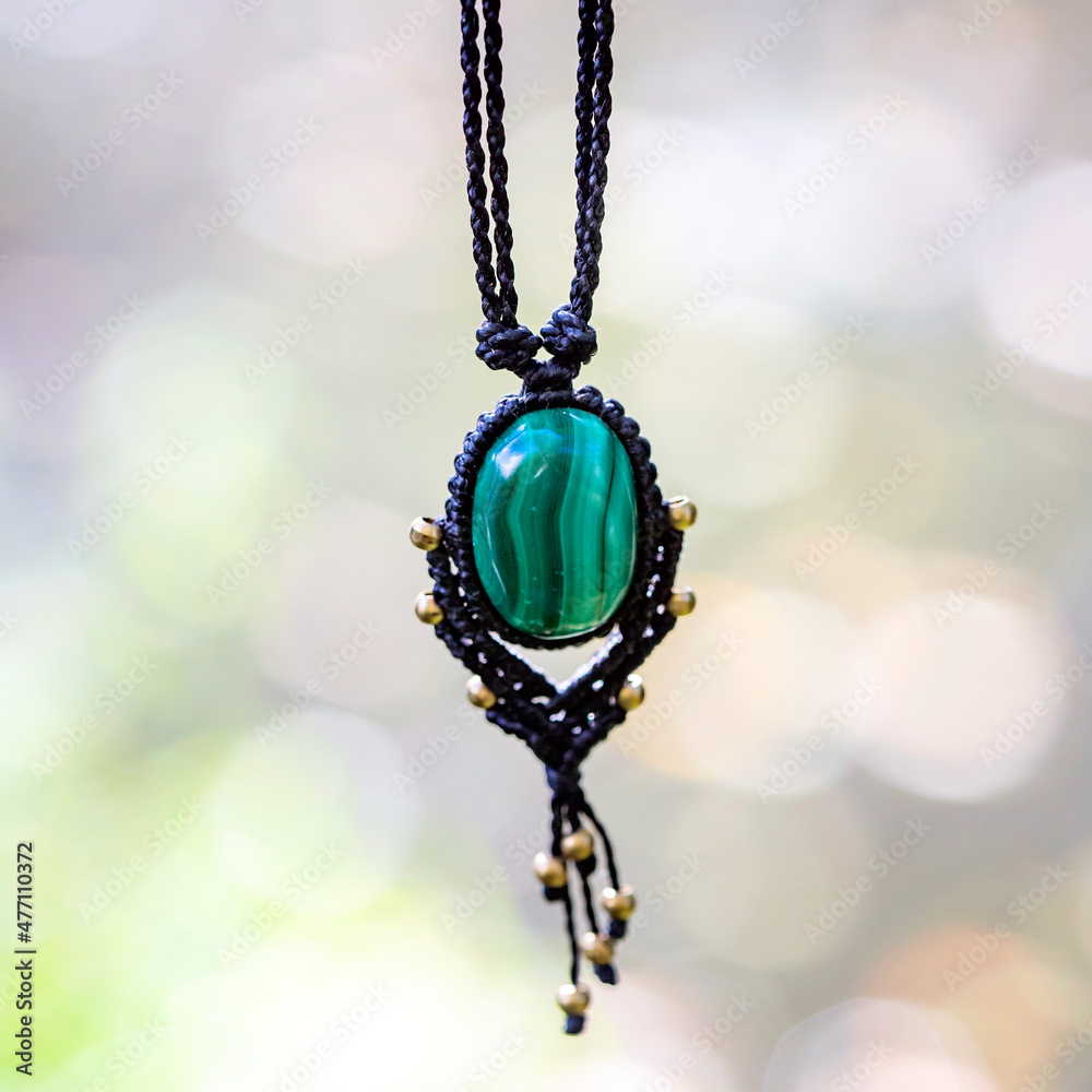 Boho necklace on natural background with green malachite stone Boho necklace on natural background with green malachite stone
