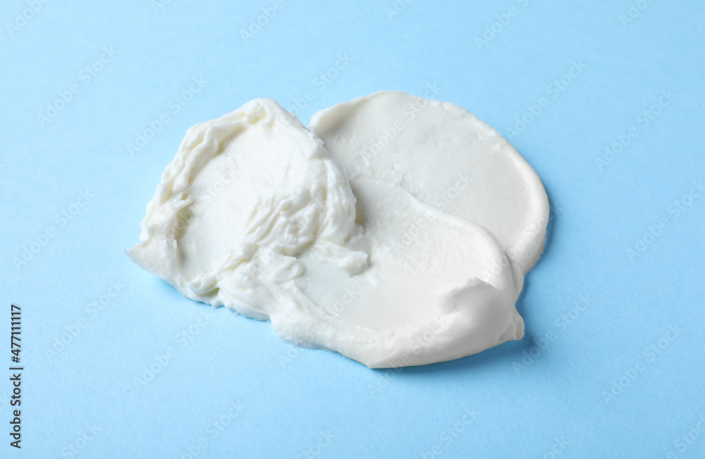 Smear of delicious cream cheese on light blue background Smear of delicious cream cheese on light blue background