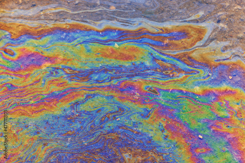 puddle gasoline background, wet oil multicolored rainbow pollution spill