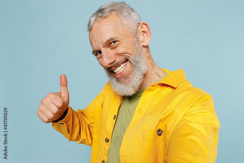Close up elderly smiling fun gray-haired mustache bearded man 50s wear yellow shirt doing selfie shot pov on mobile phone show thumb up isolated on plain pastel light blue background studio portrait Close up elderly smiling fun gray-haired mustache bearded man 50s wear yellow shirt doing selfie shot pov on mobile phone show thumb up isolated on plain pastel light blue background studio portrait