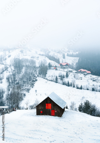 mountain hut and village on snowy hill during winter