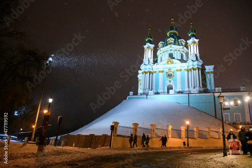 Evening snowy view of St. Andrew Church from Andriyivskyy Uzviz Descent Street in Kyiv, Ukraine. December 2021
