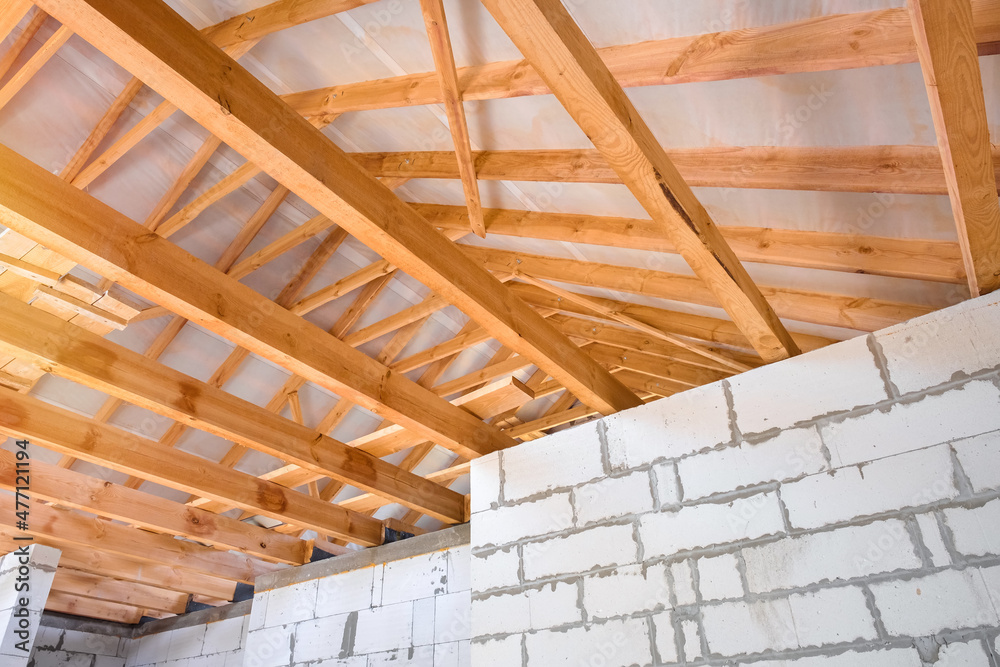 New construction of the house. Constructing a roof from timber beams New construction of the house. Constructing a roof from timber beams