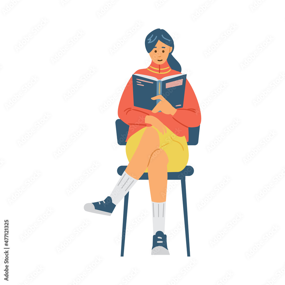Fototapeta premium Pretty girl reads book sitting on chair, student studies scientific literature
