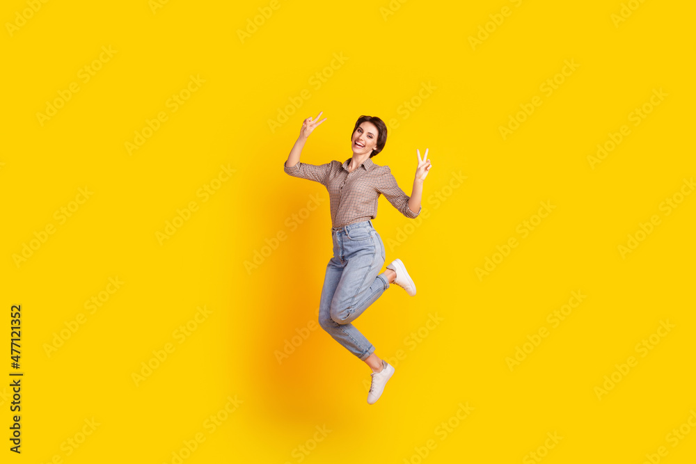 Full body profile side photo of young excited woman have fun jump show peace v-symbol isolated over yellow color background