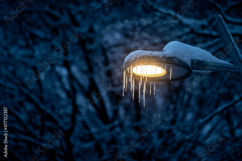 Icicles on a street lamp in the winter forest