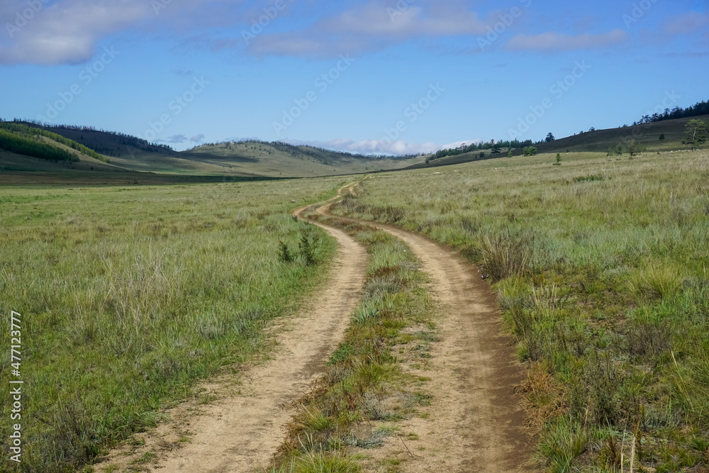 Fototapeta premium Dirt road through a beautiful valley on Olkhon island