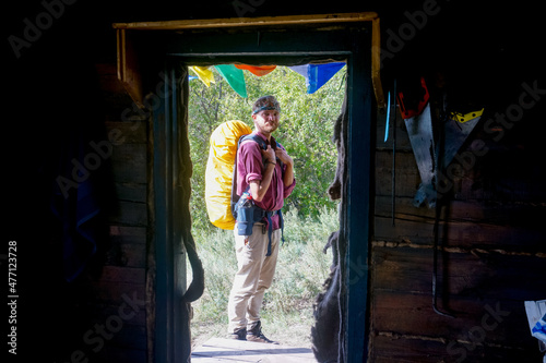 Hiker near a wooden hut on Lake Baikal
