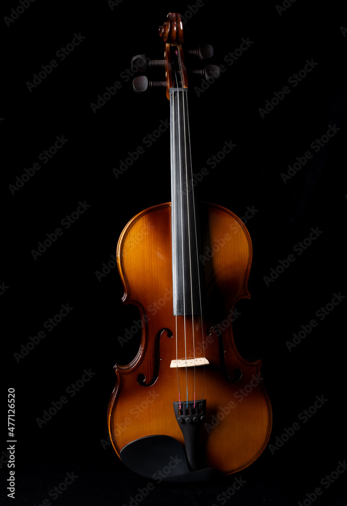 Light and shadows on a violin against a dark background. Light and shadows on a violin against a dark background.