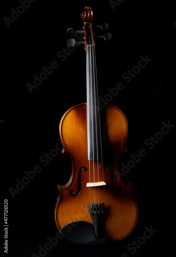 Light and shadows on a violin against a dark background.