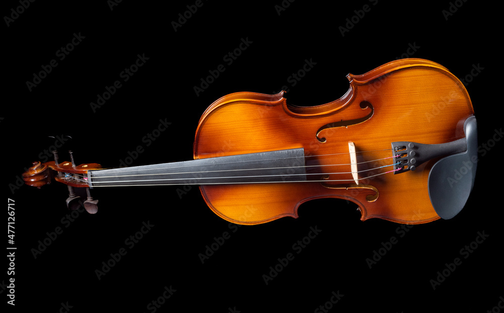 Fototapeta premium Violin lying on its side isolated on black background.