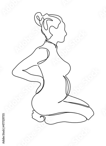 Pregnant woman sitting on her knees in profile in a dress on a white background
