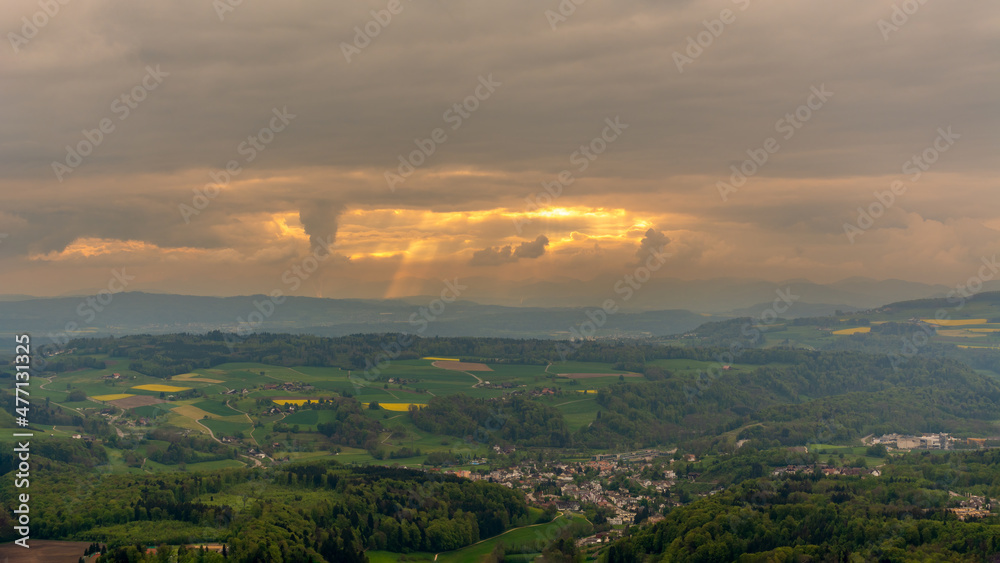 Sun rays bursting through the clouds above the cityscape Sun rays bursting through the clouds above the cityscape