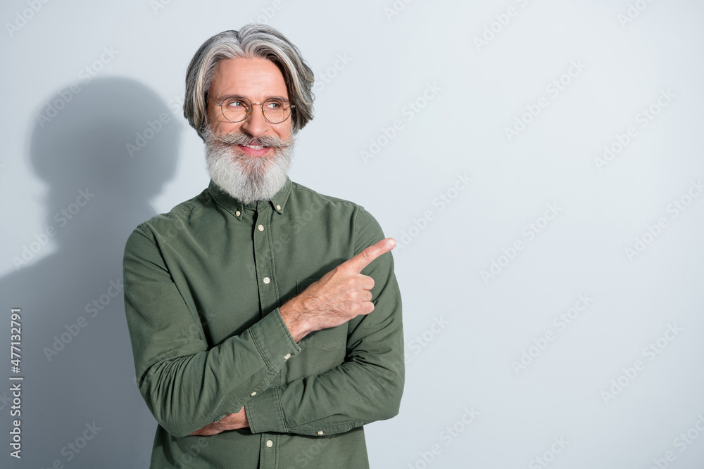 Portrait of attractive cheerful grey-haired man showing indicate index select follow copy space isolated over gray pastel color background Portrait of attractive cheerful grey-haired man showing indicate index select follow copy space isolated over gray pastel color background